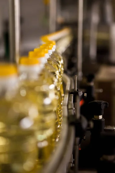 Aceite de girasol en la botella en movimiento en la línea de producción. Dof poco profundo . —  Fotos de Stock