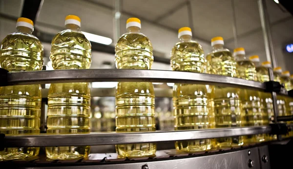 Aceite de girasol en la botella en movimiento en la línea de producción. Dof poco profundo . — Foto de Stock