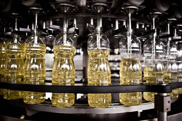 Óleo de girassol na garrafa em movimento na linha de produção. Dof rasa . — Fotografia de Stock