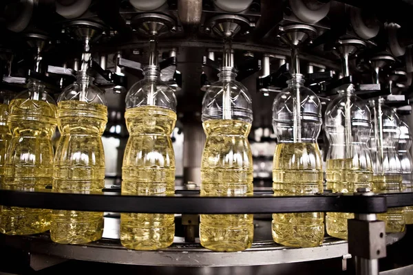 Aceite de girasol en la botella en movimiento en la línea de producción. Dof poco profundo . — Foto de Stock