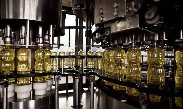 Solrosolja i flaskan flyttar produktionslinje. Grunt dof. — Stockfoto