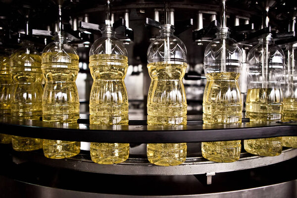 Sunflower oil in the bottle moving on production line. Shallow dof.