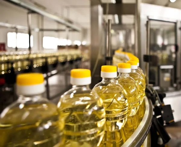 Olio di girasole in bottiglia in movimento sulla linea di produzione. Dof poco profondo . — Foto Stock