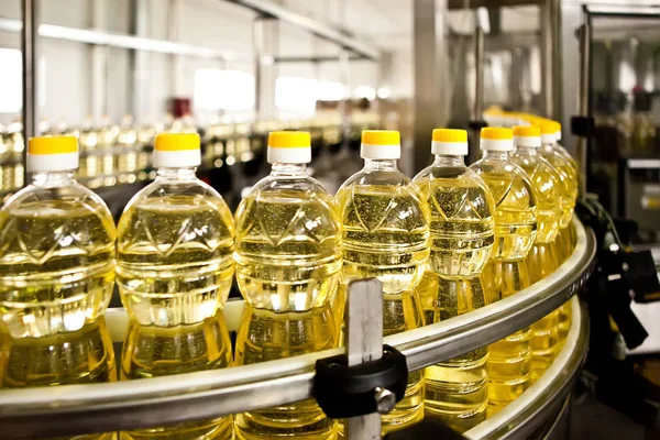 Olio di girasole in bottiglia in movimento sulla linea di produzione. Dof poco profondo . — Foto Stock