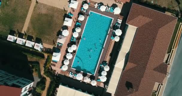 Vue aérienne du dessus de la famille dans la piscine d'en haut, la mère heureuse et les enfants nagent sur des beignets gonflables et s'amusent dans l'eau pendant les vacances en famille . — Video