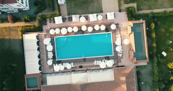 Vista aerea dall'alto della famiglia in piscina dall'alto, madre felice e bambini nuotano su ciambelle ad anello gonfiabili e si divertono in acqua in vacanza in famiglia . — Video Stock