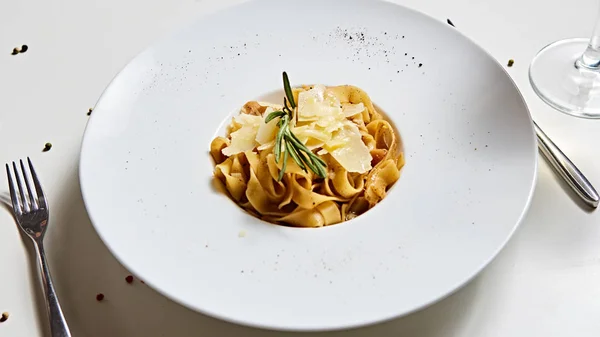 Placa de pasta italiana de primer plano con queso parmesano rallado y hoja de albahaca — Foto de Stock