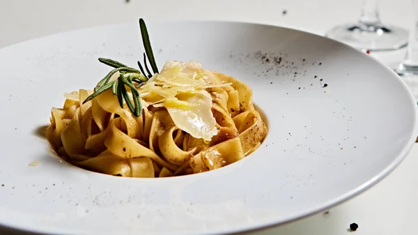 Placa de pasta italiana de primer plano con queso parmesano rallado y hoja de albahaca — Foto de Stock