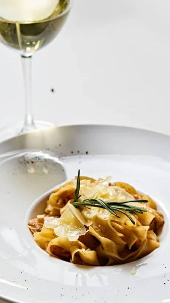 Placa de pasta italiana de primer plano con queso parmesano rallado y hoja de albahaca — Foto de Stock