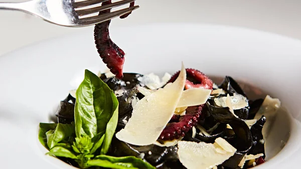 Nudeln mit schwarzer Tintenfischtinte, Kraken und Parmesan. — Stockfoto