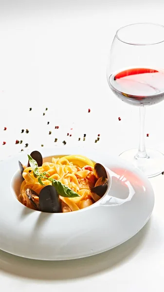 The cooked mussels and pasta with wine glass. — Stock Photo, Image