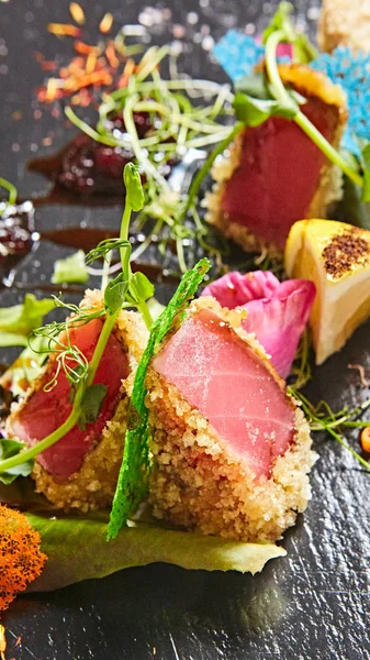 Close up van zeldzame aangebraden Ahi tonijn segmenten met verse fruit salade op een plaat. — Stockfoto