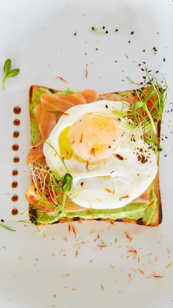 Яйцо бенедикт с голландским соусом и копченым лососином на тосте. Вкусный завтрак . — стоковое фото