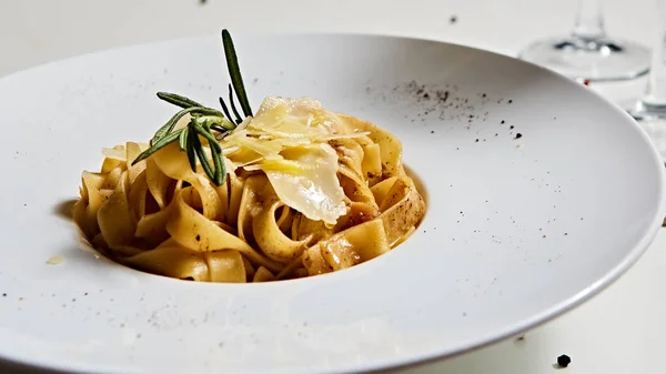 Close-up italian pasta plate with grated parmesan cheese and basil leaf — Stock Photo, Image