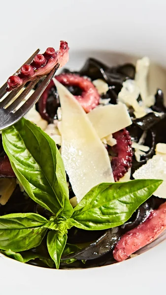 Pasta with black cuttlefish ink, octopuses and parmesan. — Stock Photo, Image