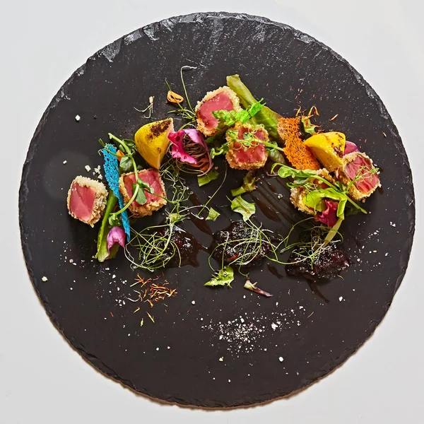 Close up van zeldzame aangebraden Ahi tonijn segmenten met verse fruit salade op een plaat. — Stockfoto