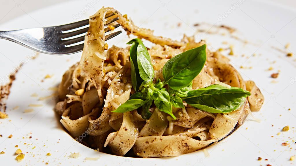 Tagliatelle with mushrooms and decorated with basil leaves.