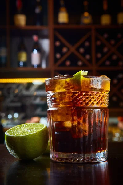 Vista de alto ângulo de um copo de coquetel Cuba Libre com rum, coque, suco de limão e cubos de gelo — Fotografia de Stock
