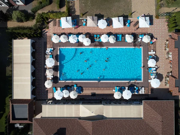 Aerial view on people in swimming pool. Top view of people sunbathing pool.