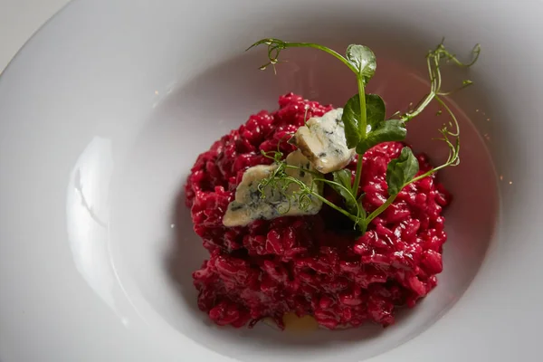 Risoto de beterraba com queijo azul em um prato branco . — Fotografia de Stock