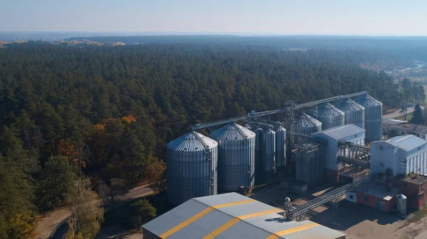 Metal grain elevator inagricultural zone in forest — Stock Photo, Image