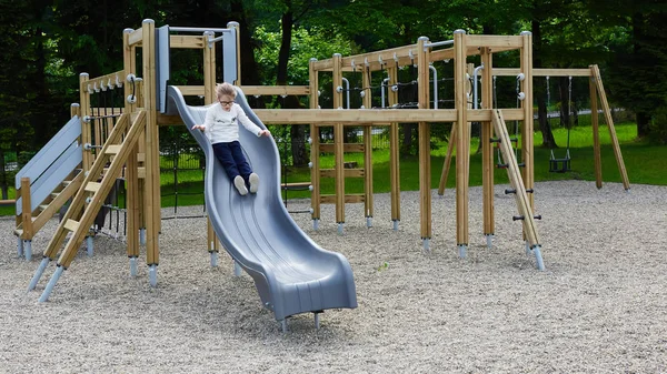 Μικρό κορίτσι σε μια παιδική χαρά. Παιδιά που παίζουν σε εξωτερικούς χώρους το καλοκαίρι. Τα παιδιά παίζουν στην αυλή του σχολείου. — Φωτογραφία Αρχείου