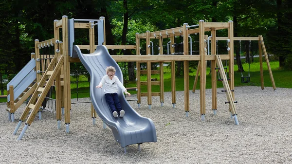 Little girl on a playground. Child playing outdoors in summer. Kids play on school yard. — Stock Photo, Image