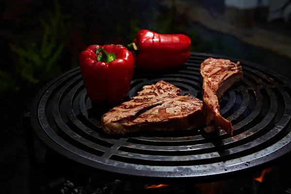 Tomahawk rib beef steak and T-bone on hot black grill. — Stock Photo, Image