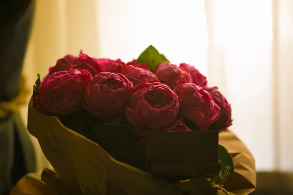 Stäng upp vackra röda rosor bukett med glödande ljus bakgrund för alla hjärtans dag och kärlek tema. — Stockfoto