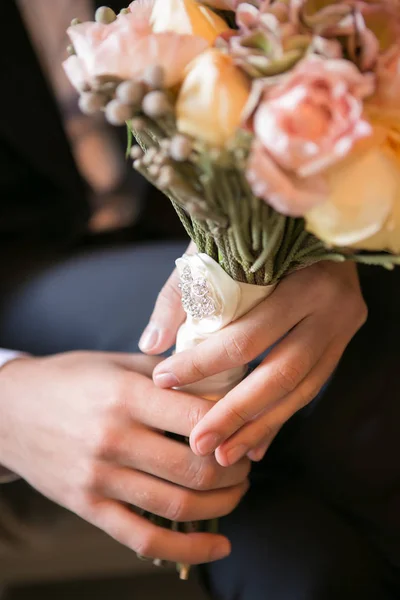 Bruidegom holding in handen gevoelig, dure, trendy Bruidssuite bruiloft boeket van bloemen — Stockfoto