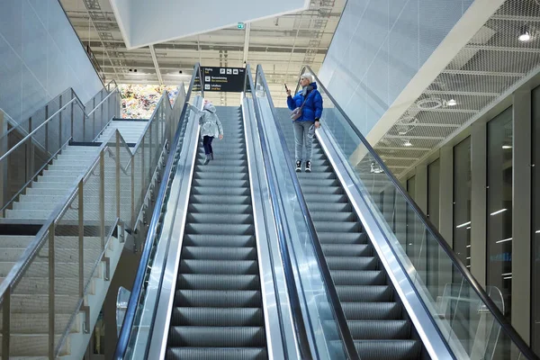 Mãe e filho juntos no fundo da escada rolante. Terminal, viagens no aeroporto, cuidados amorosos . — Fotografia de Stock