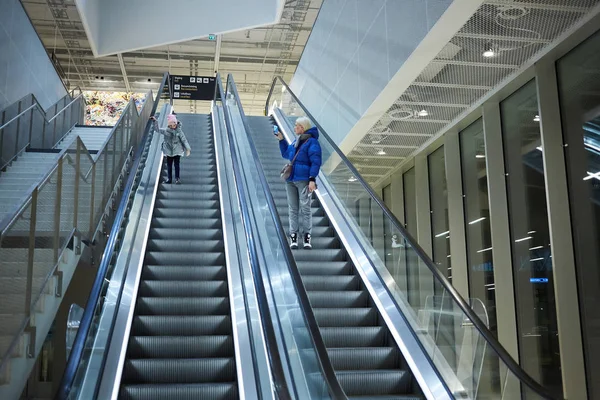 Mãe e filho juntos no fundo da escada rolante. Terminal, viagens no aeroporto, cuidados amorosos . — Fotografia de Stock