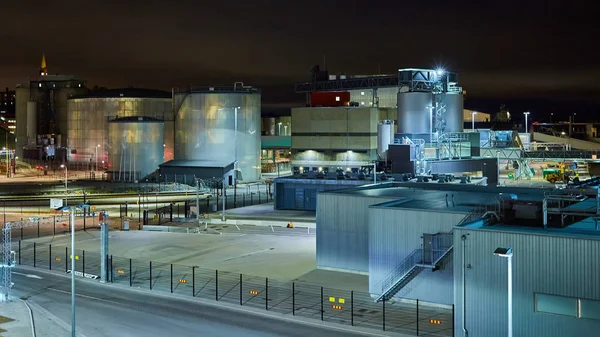 Modern grain terminal at night. Metal tanks of elevator. Grain-drying complex construction. Commercial grain or seed silos at seaport. Steel storage for agricultural harvest — Stock Photo, Image