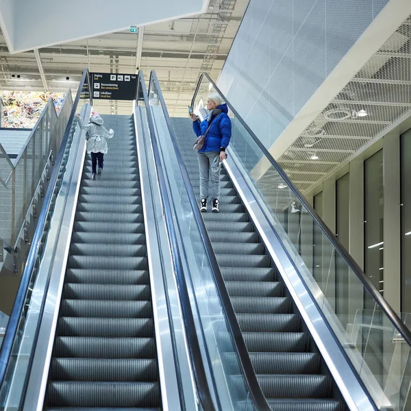 Madre e hijo juntos en el fondo de la escalera mecánica. Terminal, viajes al aeropuerto, cuidado del amor . —  Fotos de Stock