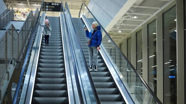Modern och barnet tillsammans på rulltrappan bakgrund. Terminal, flygplats resor, kärlek vård. — Stockfoto