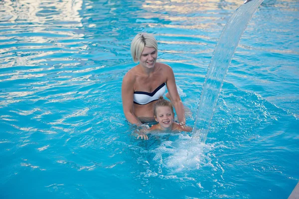 快乐的妈妈和女儿在游泳池里玩耍 — 图库照片