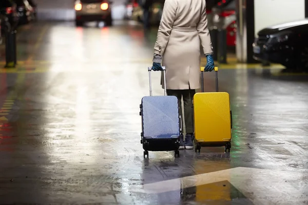 2 つのスーツケースを持つ女性を歩いての背面します。動きの美しい少女。荷物を持つ旅行者の裏面表示 — ストック写真