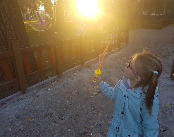 夏の公園でシャボン玉を吹く少女. — ストック写真