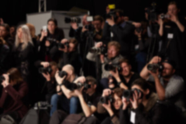 Abstract blurred photographer and reporter at fashion show.