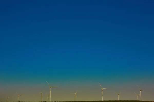 Grön äng med vindkraftverk som alstrar elektricitet — Stockfoto