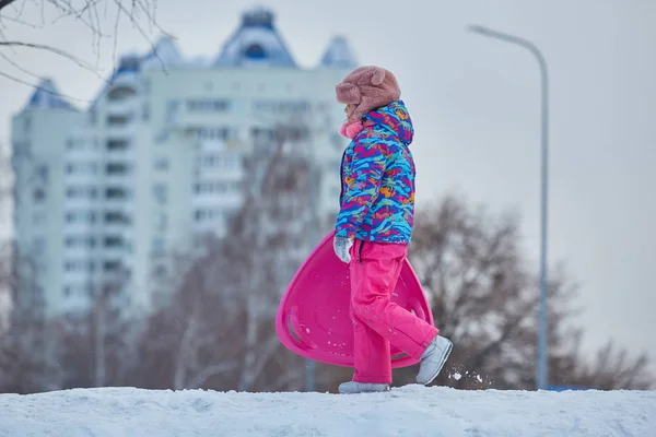 Kleines Mädchen reitet im Winter auf Schneerutschen — Stockfoto