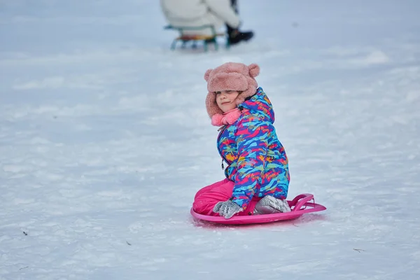 Menina cavalgando em escorregas de neve no inverno — Fotografia de Stock