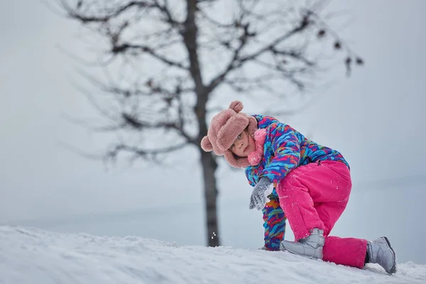 Menina cavalgando em escorregas de neve no inverno — Fotografia de Stock