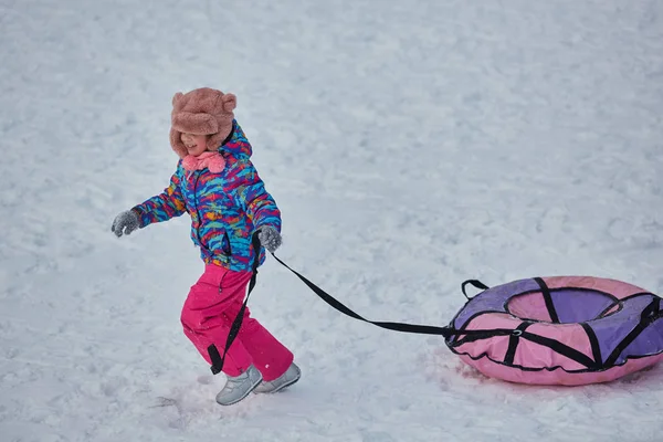 Κοριτσάκι και ιππασία σε χιόνι διαφάνειες στο χειμώνα — Φωτογραφία Αρχείου