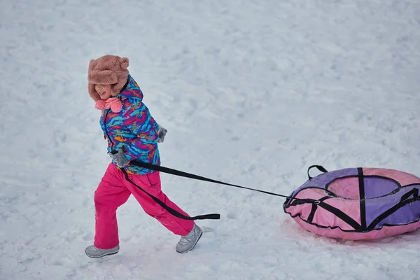 Snímky holčička jízdu na sněhu v zimním období — Stock fotografie