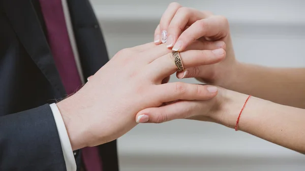 Novia poniendo un anillo de bodas en los novios dedo. — Foto de Stock