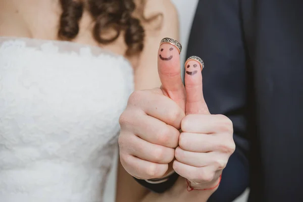 Wedding rings on their fingers painted with the bride and groom, funny little people — Stock Photo, Image