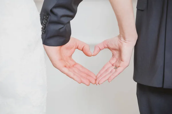 Hochzeitspaar zeigt Herzform aus den Händen. — Stockfoto