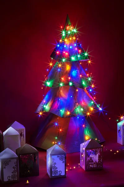 Árbol de Navidad de cartón con luces multicolores por la noche —  Fotos de Stock