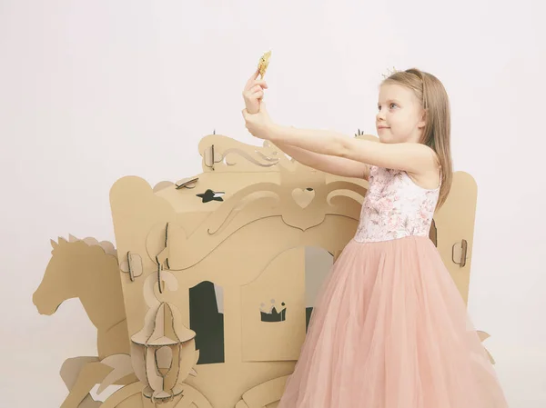 Mała księżniczka patrzy w lustro. Mała dziewczynka trzymać lustro. Moda i uroda, dzieciństwo. Dziecko dziewczynka w stylowy sukienka — Zdjęcie stockowe